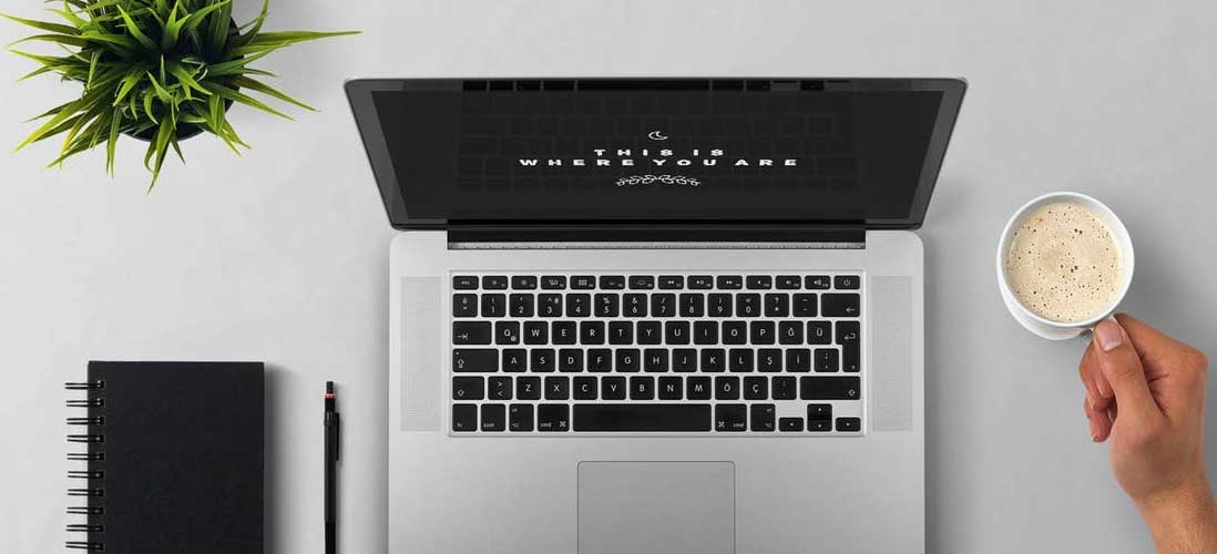 Desk with laptop, notebook and coffee during a content audit