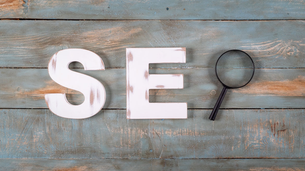 SEO letters and a magnifying glass on a wooden desk